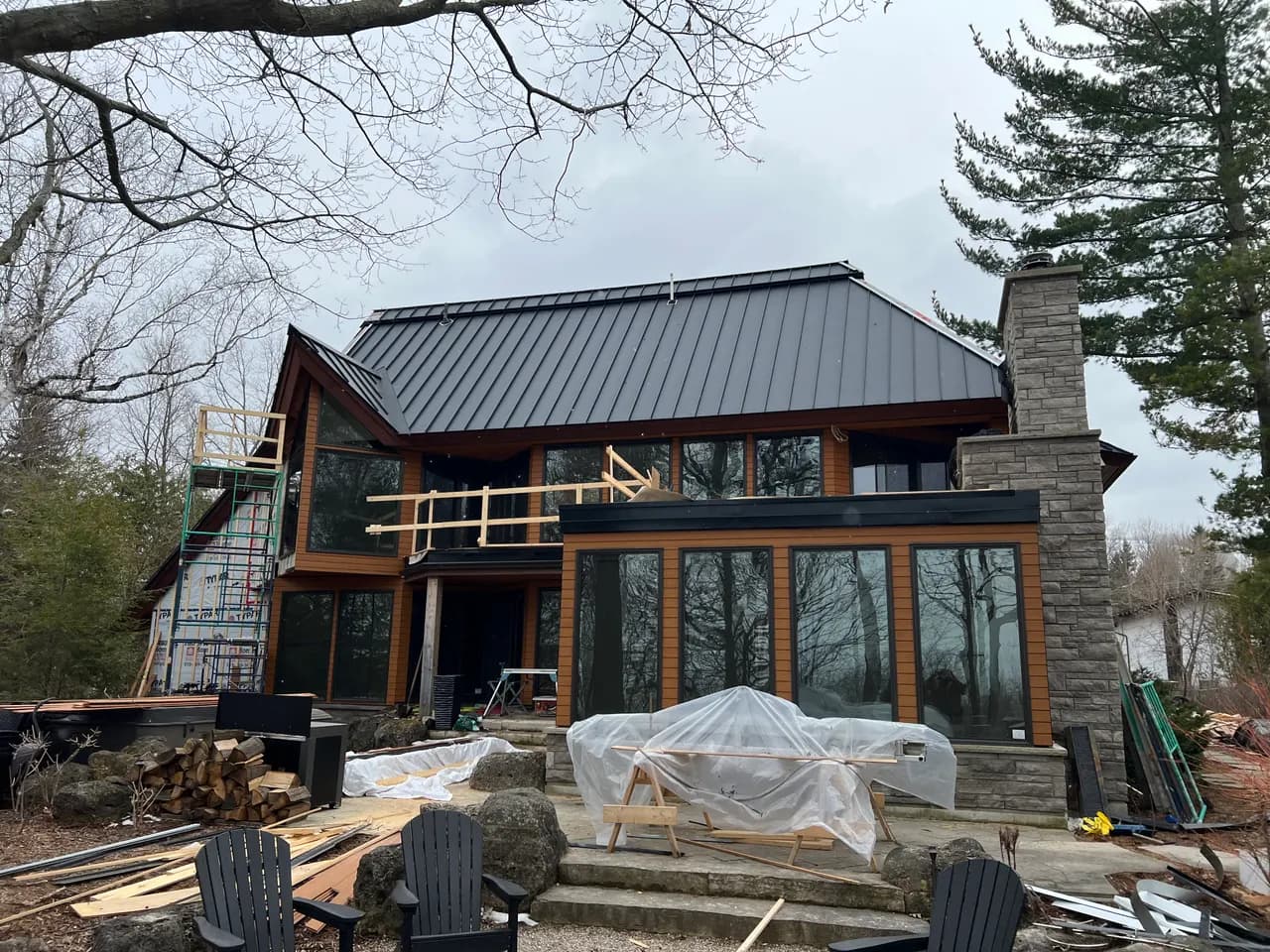 Mixed-material modern lakehouse with metal roof, stone, and wood